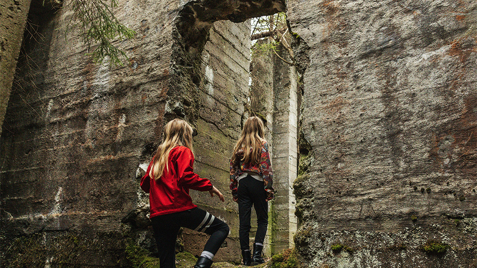 Barn som utforskar ruiner av gamla gruvbyggnader. 